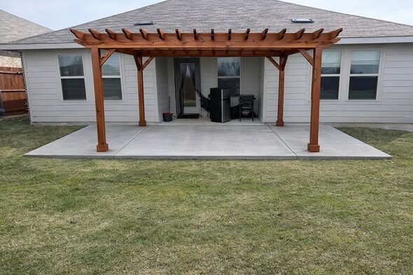 Cedar pergola over a finished concrete patio on a North Texas backyard